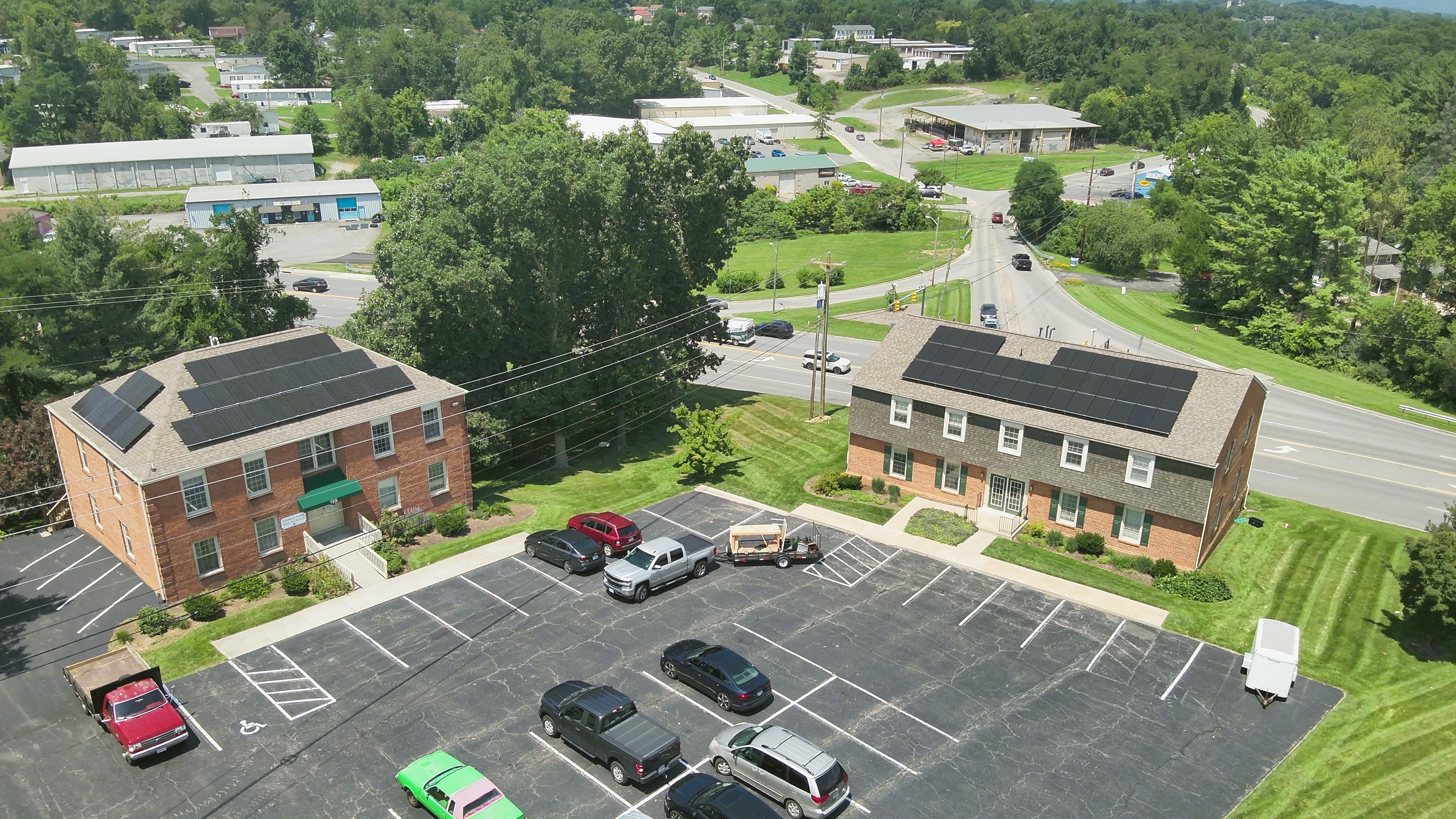 Aerial drone view of commercial solar panel arrays installed on two Valley Wide Management office buildings in Christiansburg, Virginia.